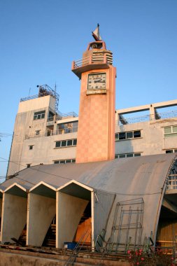 Gün batımında geometrik desenlere sahip uzun saat kulesi.