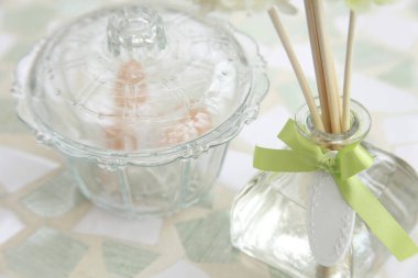 Cam vazo, aroma çubukları ve cam kase. 