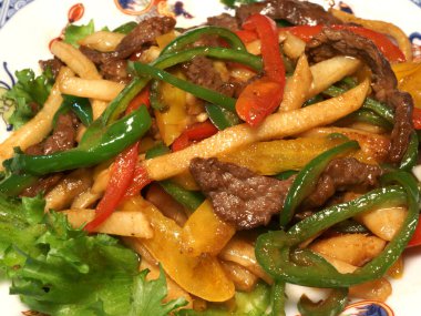 Renkli dolmalık biberli kızarmış biftek.