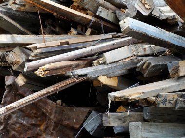 Kırık ahşap kirişler metal molozlar ve molozların arasına dağılmış.