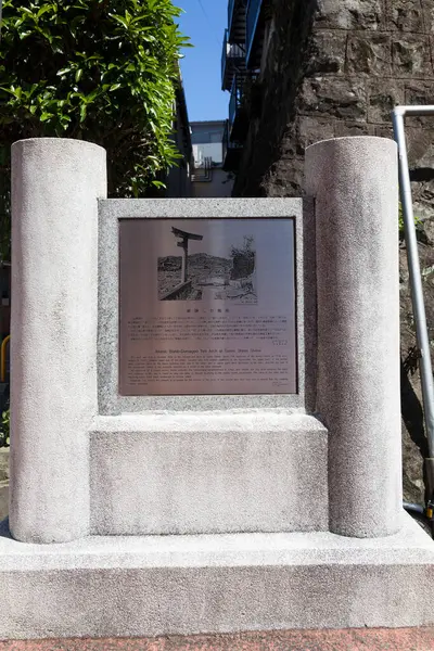 Japonya 'nın Nagasaki kentindeki Sann Tapınağı' ndaki tek bacaklı Torii Kapısı 'nda bilgi tahtası. Bu taş torii kapısı, şehrin 1945 'teki atom bombasından kurtulan tarihi bir simgedir.. 