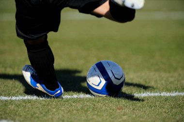 Spor giyim sektöründe futbol oyuncusunun bacakları çimlerin üzerinde top oynuyor.                 