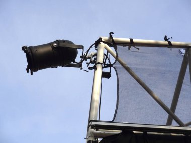 Sahne ışıkları açık mavi gökyüzüne karşı metal çerçeveye monte edildi