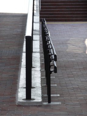 Şehir ortamında beton basamaklar boyunca metal korkuluklar