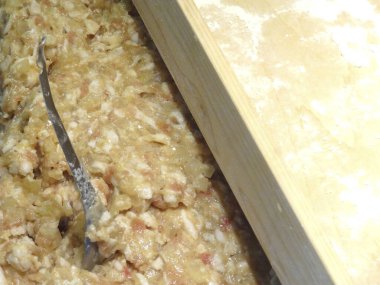 Ahşap kesim tahtasının yanında çiğ et karıştırmak