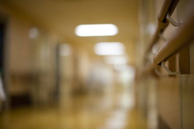 Arka planda hastane koridoru boş.