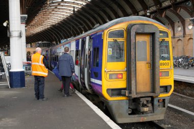 Tren ve insanlarla dolu bir tren istasyonu.  