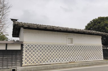 Kafes duvarı ve fayanslı çatısı olan geleneksel Japon binası.