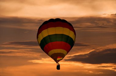 Günbatımında gökyüzünde uçuşan renkli sıcak hava balonu 