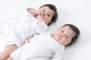 Beyaz arka planda yatan iki bebek