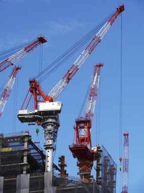 construction cranes and building under blue sky background