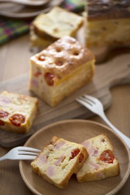 Mutfak masasında peynirli, jambonlu ve sebzeli lezzetli ev yapımı ekmeğin yakın plan görüntüsü.        