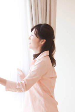 Asyalı kadın pencereye bakıyor.