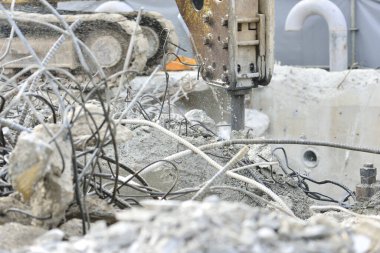 Dışarıdaki yıkım sırasında beton moloz kıran kazıcı.