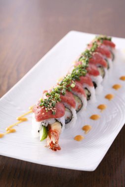 Suşi beyaz tabakta yuvarlanıyor.