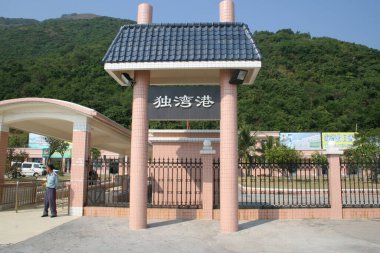 Siyah işaretli giriş kapısı ve arkasında dağlar.