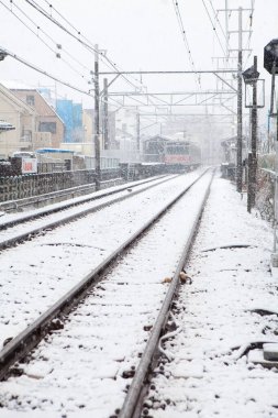 Tren kış mevsiminde demiryolunda hareket ediyor.