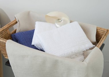 İçinde çeşitli renklerde katlanmış havlular olan dokuma sepet.