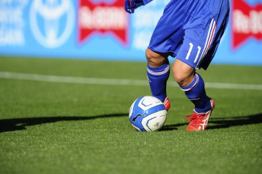 Spor giyim sektöründe futbol oyuncusunun bacakları çimlerin üzerinde top oynuyor.                 