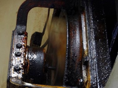 Yakın plan paslı endüstriyel parçayı dönen tekerlekle gösteriyor