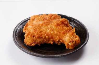 Siyah tabakta kızarmış tavuk. Beyaz arka planda izole edilmiş..