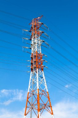 Mavi gökyüzüne karşı yüksek voltajlı elektrik hatları