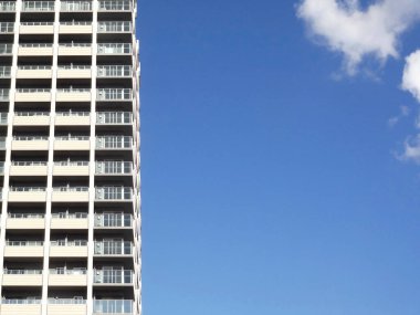 Mavi gökyüzü arkaplanındaki modern şehir binasının düşük açılı görüntüsü      