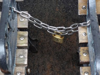 Asma kilit ahşap yapıya metal zincir takıyor.
