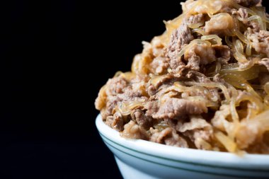 Arka planda pilav ile pişirilmiş et kasesi