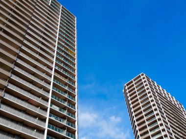 Mavi gökyüzüne karşı modern yüksek binaların düşük açılı görüntüsü              