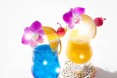 cocktails in glasses with flowers on white background clipart