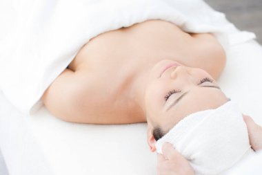 Asyalı kadın kafa masajı yaptırıyor, kaplıcada dinleniyor.