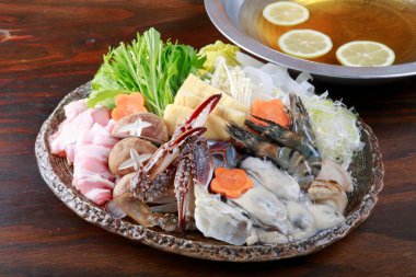 Tabakta çeşitli deniz ürünleri ve sebzelerin olduğu bir mutfak fotoğrafı.