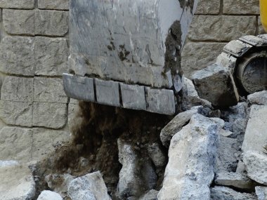 İnşaat alanında yıkılan binalarla çalışan ağır endüstriyel makineler.           