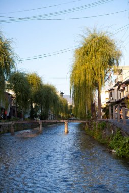 Kanalı ve köprüsü olan küçük Japon kasabasının sokak fotoğrafı.   