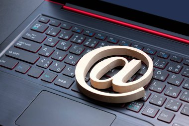 Arka planda e-posta sembolü ve dizüstü bilgisayar klavyesi, kapat