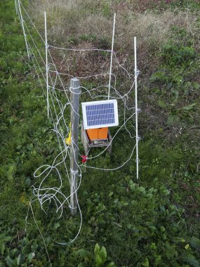 Güneş paneli dışarıdaki tellerin içinde küçük turuncu bir cihaza güç veriyor.