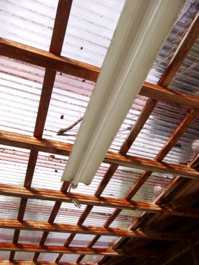 Floresan lamba ahşap çerçeveli çatının altında asılı.