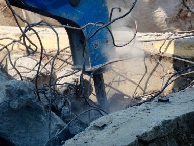 İnşaat alanında yıkılan binalarla çalışan ağır endüstriyel makineler.           