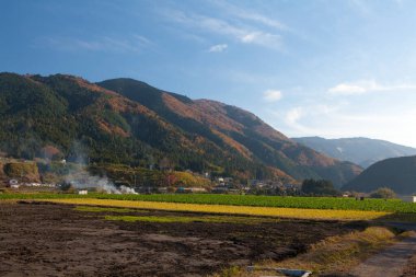 Köyün üstündeki mavi bulutlu gökyüzü Renkli dağlarda, gündüz manzaralı