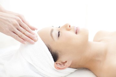 Asyalı kadın kafa masajı yaptırıyor, kaplıcada dinleniyor.