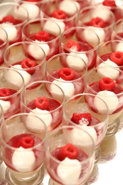 Bardaklar lezzetli tatlılar ve ahududular masada.