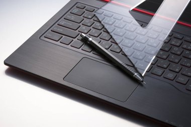 Masaüstünde kalem ve cetvel olan dizüstü bilgisayar, üst görünüm