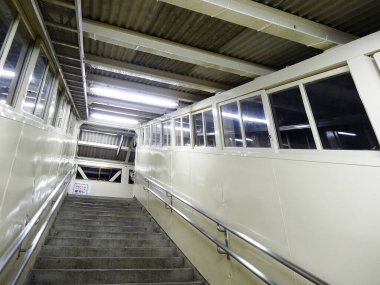 Boş beton merdiven kapalı yürüme yolunun yanında yükseliyor.