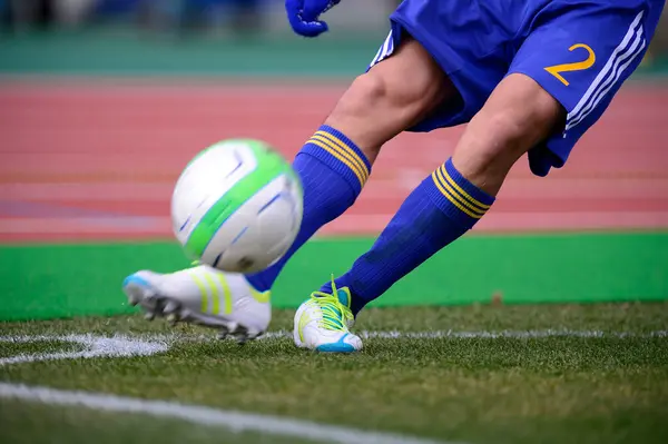 サッカー選手がフィールドでサッカーボールを蹴る — ストック写真