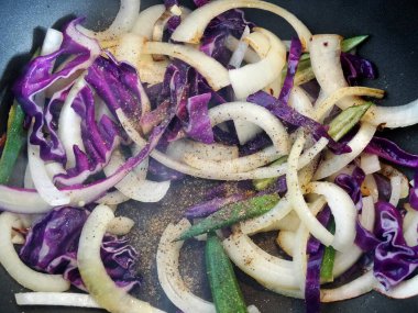 Kızartma tavasında baharatlı ve sebzeli soğan, yakın plan.         