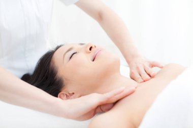 Asyalı kadın kafa masajı yaptırıyor, kaplıcada dinleniyor.