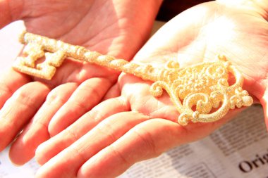 Dekoratif altın anahtar taşıyan kişinin yakın plan görüntüsü               