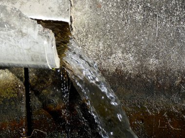 Eski paslı, su dolu metal boru.