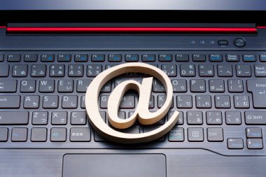 Arka planda e-posta sembolü ve dizüstü bilgisayar klavyesi, kapat